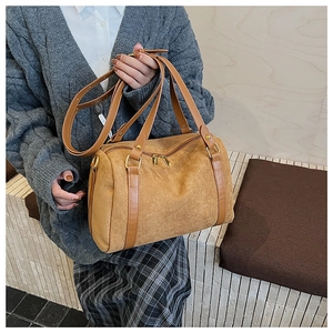 Détails du sac boston en daim beige avec poignées en cuir et fermeture éclair dorée