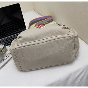 Detail of beige nylon crossbody bag with colorful SJCHAO embroidered strap and red logo