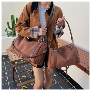 Ensemble de sacs Boston en daim marron avec bandoulières dans un décor extérieur
