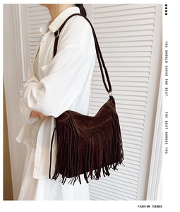 Detail of bohemian brown suede fringe bag with long tassels and adjustable strap