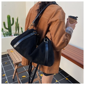 Détail du grand sac Boston en daim noir avec ferrures dorées et bandoulière réglable