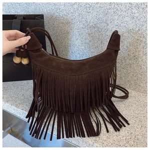 Detail of bohemian dark brown suede tassel bag featuring stylish round wooden beads