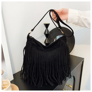 Detailed view of bohemian black faux suede fringe bag with golden ring hardware