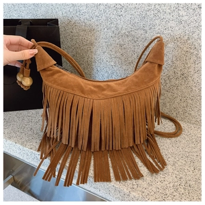 Detail of brown suede crescent bag with double-layered tassels and wooden beads