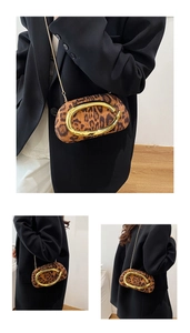 Détails du sac léopard avec poignée anneau dorée et chaîne sur un costume noir chic