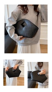 Detail of black woven leather tote bag with classic crisscross texture and top handle