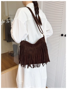 Detail view of brown suede fringe crossbody bag showing bohemian tassel design and soft texture