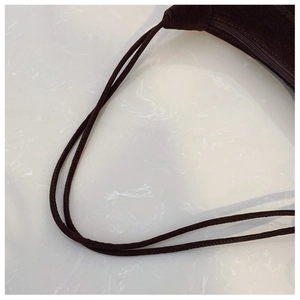 Detail of dark brown suede bucket bag with dual thin shoulder straps and zipper closure