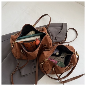 Détails des sacs Boston en daim en deux tailles montrant l'intérieur et les poignées en cuir