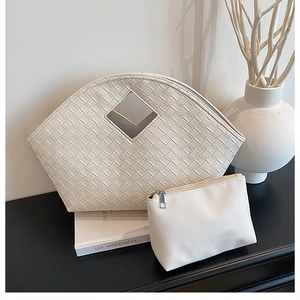 Close-up of beige woven tote bag set with rhombus cutout handle and matching pouch