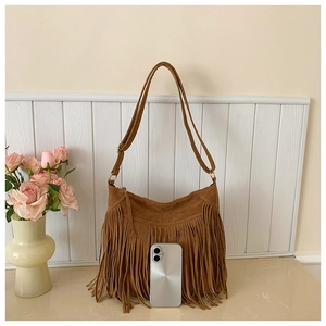 Detailed view of brown matte suede Hobo bag with long bohemian fringes and gold hardware
