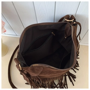 Detailed top view of brown suede bag showing interior black lining and zipper pocket