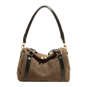 Détail d'un sac Boston en daim marron avec bordure en cuir noir et zips en métal doré