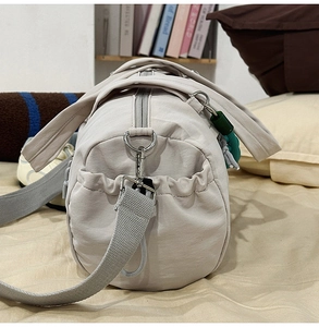Dettaglio borsa sportiva in nylon grigio chiaro con doppi manici e tasche laterali