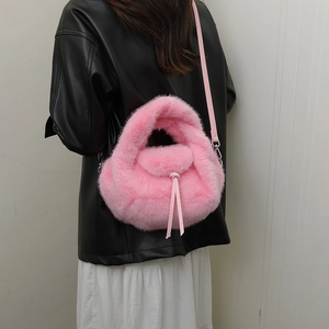 Pink plush faux fur handbag with leather shoulder strap shown in a model styling shot