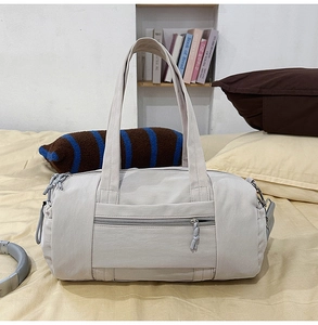 Dettaglio della borsa da viaggio in nylon capiente con doppia cerniera e manici rinforzati