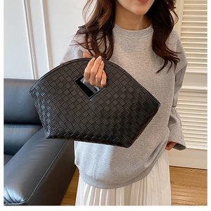 Detail view of woven leather basket bag texture and chic diamond-shaped cutout handle