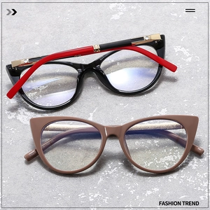 Detail of cat eye glasses with gold metal hinges and rhinestones on a cement background
