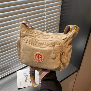 Beige nylon crossbody bag with multi-pockets and purple-yellow woven shoulder strap