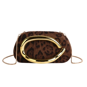 Détail d'un sac de soirée léopard avec boucle dorée en arc et bandoulière en chaîne