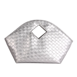 Detail of silver woven tote bag featuring metallic finish and diamond-shaped cutout handle