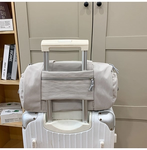 Detail der grauen Reisetasche mit rückseitiger Lasche für den Koffergriff
