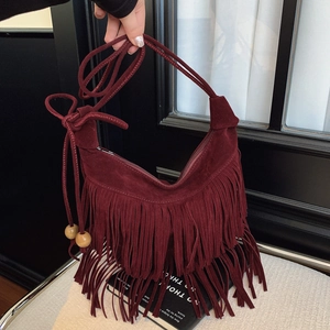 Burgundy faux suede tassel bucket bag with wooden bead details and adjustable strap