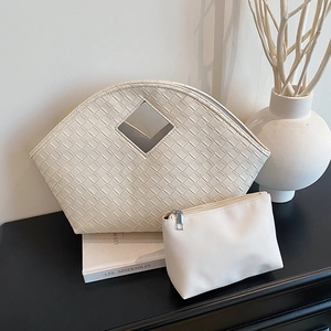 Chic beige woven tote bag set with a matching pouch on a sleek black surface