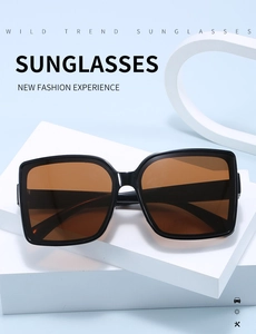 Detail of square oversized white sunglasses with dark lenses on a geometric base