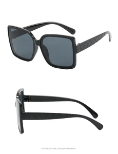 Close-up of black oversized square sunglasses with diamond-quilted texture on temples