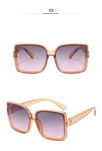 Macro detail of orange frame sunglasses with gradient lenses and textured diamond pattern temples