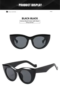 Detail view of shiny black cat-eye sunglasses with dark grey lenses in studio lighting