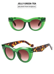 Detail view of jelly green cat eye sunglasses with tea lenses and tortoise temples