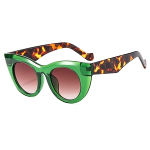 Oversized cat-eye sunglasses with transparent green frames and leopard print temples
