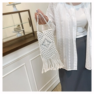 Détail de la pochette téléphone en coton blanc tressé avec nœuds et longues franges