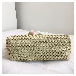 Detailed base view of the large capacity beige woven straw beach bag showing wide bottom