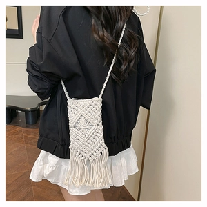 Detailed view of handmade woven cotton fringe phone bag on a cross-body strap