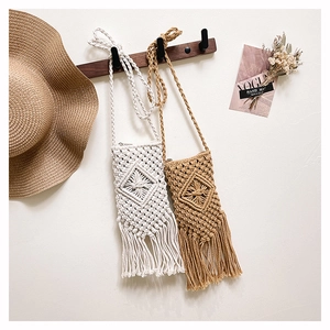 Détail de sacs de téléphone bohèmes tissés main avec franges et motifs losanges