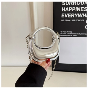 Detail of silver crescent acrylic mini evening bag with mirror finish and chain strap