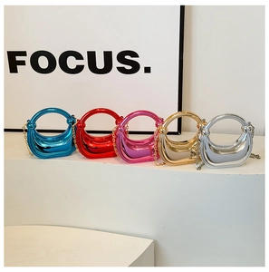 Close-up of five mini crescent acrylic evening bags in metallic mirror finishes and colors