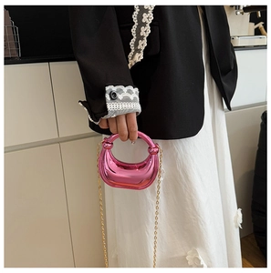Detailed macro view of pink metallic crescent evening bag with gold ring handle and chain
