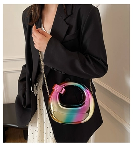 Macro view of gradient acrylic box bag with metallic circular handle and gold chain strap
