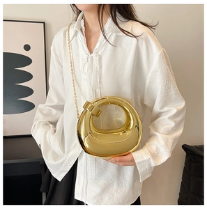 Detail of mirror gold acrylic evening bag with metal handle and chain strap for women