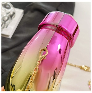 Detail of pink-gold gradient acrylic box bag with metallic finish and gold chain strap