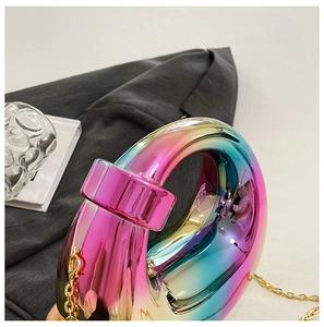 Detail of colorful gradient acrylic clutch with circular handle and gold metal chain