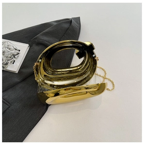 Detail of a luxury gold mirror acrylic clutch bag with a unique hollow circular metal frame