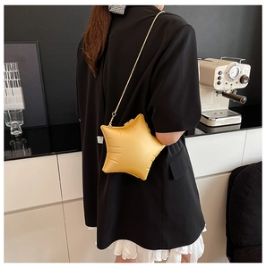 Detail of yellow star-shaped crossbody bag featuring textured surface and gold snake chain