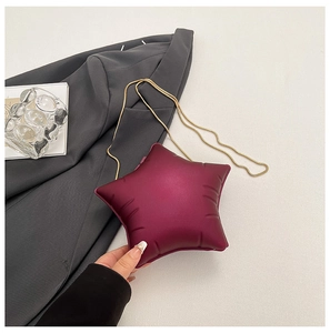 Close-up of wine red star-shaped bag with gold chain strap and quilted texture