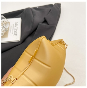 Close-up of yellow star-shaped PVC bag featuring a gold chain and geometric ridges