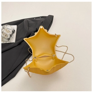 Detailed interior of yellow star-shaped crossbody bag with magnetic closure and gold chain